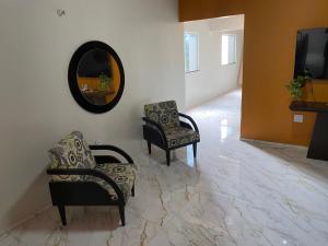 カモシンにあるapartamento Aconchego 1のリビングルーム(椅子2脚、鏡付)