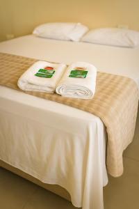 a bed with white towels sitting on top of it at Pousada do Andrade in Ponta Porã