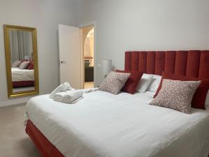 een groot bed met een rood hoofdeinde en een spiegel bij Luxury Home Estefania in Chayofa +35 foto's