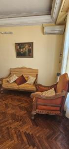 un soggiorno con 2 letti e una sedia di Gualeguay Centro a Gualeguay