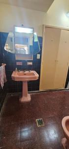 bagno con lavandino rosa e specchio di Gualeguay Centro a Gualeguay