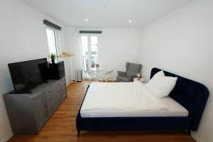 ein Schlafzimmer mit Bett und Flachbildfernseher in der Unterkunft Livery in Koblenz