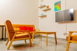 a living room with a couch and a table and a tv at T3 Duplex - Tsimkoura in Chirongui