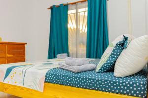 a bed with blue and white polka dot sheets and pillows at T3 Duplex - Tsimkoura in Chirongui
