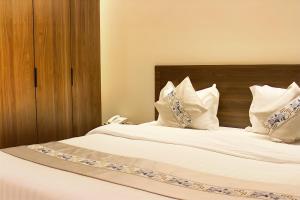 a bedroom with a bed with white sheets and pillows at النسمة الهادئة in Jeddah