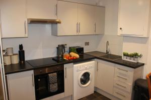 eine Küche mit einer Waschmaschine und einem Geschirrspüler in der Unterkunft Oliver Wests Beautiful 2 Bedroom Sleeps 4 Apartment in Scarborough + 23 Fotos