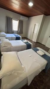 Residencial Paraviana-Casa Piscina في بوا فيستا: غرفة بها أربعة أسرة في الغرفة +31 صورة