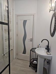 een badkamer met een deur met een wastafel en een toilet bij East apartment in Tecuci