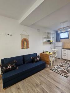 een woonkamer met een blauwe bank en een keuken bij East apartment in Tecuci