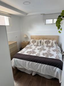 una camera da letto con un letto con un piumone bianco e nero di Apto con piscina y barbacoa a La Alcayna Altre 52 foto