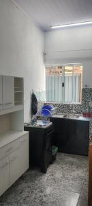 a kitchen with a sink and a stove in it at Kitnet montanha magica 3 in São Thomé das Letras +18 photos