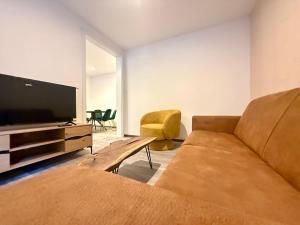 uma sala de estar com um sofá e uma TV de tela plana em Treehouse - Alpinlake Apartments em Grünau im Almtal