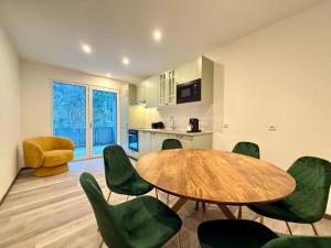 uma sala de jantar com uma mesa e cadeiras verdes em Treehouse - Alpinlake Apartments em Grünau im Almtal