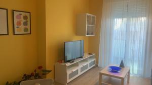 a living room with a television and a table at Appartamento L'Aurora in Gabicce Mare