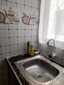 a kitchen with a sink and a tiled wall at Mwembeni Abode in Bamburi