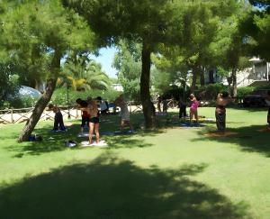 a group of people standing under trees in a park at Casa Orchidea in Botricello