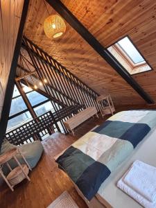 una camera da letto con letto e sedie in mansarda di Transilvania Chalet a Zărneşti Altre 9 foto