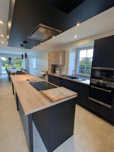 a large kitchen with a large wooden counter top at La Petite Reine in Bertrix