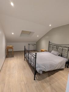 a bedroom with a bed and a wooden floor at La Petite Reine in Bertrix +10 photos