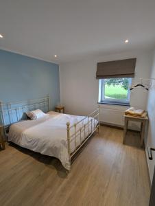 a bedroom with a large bed and a window at La Petite Reine in Bertrix