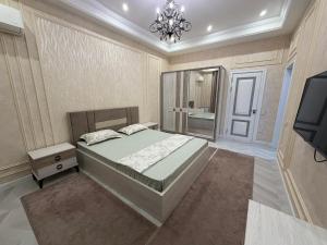 Un dormitorio con una cama grande y un televisor. en Tashkent City Apartments E2, en Tashkent