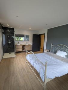 a bedroom with a large bed and a bathroom at La Petite Reine in Bertrix