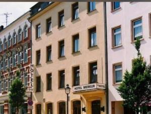 a large white building with a sign on it at Hotel Merkur in Zwickau