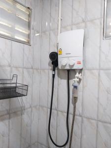 ein Badezimmer mit einer weißen Dusche mit Schlauch in der Unterkunft Little Shark bungalow in Ban Bang Bao