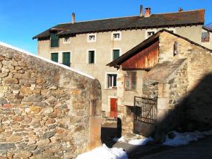 an old stone building with a stone wall and a building at Gîtes de la Ferme Basso in Planès