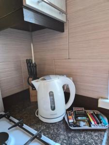 a white tea kettle sitting on top of a kitchen counter at Guest house in Umanʼ