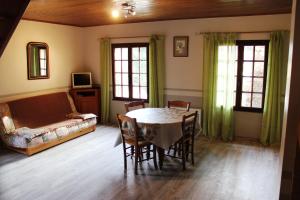 a living room with a table and chairs and a couch at Gîtes de la Ferme Basso in Planès