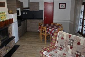 a kitchen with a table and a couch and a table at Gîtes de la Ferme Basso in Planès