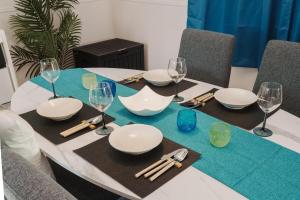 uma mesa com pratos brancos e copos de vinho em Sunstone Residence 2F - Free Rental Car included! em Ginowan