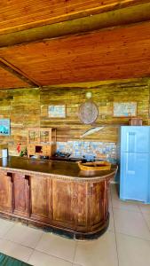 a kitchen with a wooden counter and a blue refrigerator at Bangalô Maria Vista Mar, Luxo em Trancoso in Porto Seguro