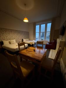 a living room with a table and a bed and a couch at Piccolo Guest House in Glasgow
