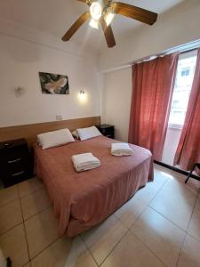 Un dormitorio con una cama grande con dos toallas encima. en San Remo Grand Hotel, en Mar del Plata