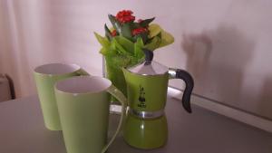 two green cups on a table with a vase of flowers at Casa Monchieri in Marone