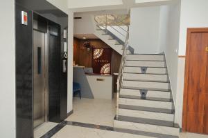 a staircase leading to a hallway with a kitchen at Aranya in Thanjāvūr