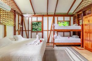 Private Villa with Pool & Heated Jacuzzi, AC, Jungle Garden Near Amenities & Beach في Talamanca: غرفة بسريرين بطابقين في منزل +70 صورة