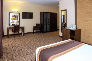 Una habitación de hotel con una cama, un escritorio y una computadora. en Hotel 33 Kampala, en Kampala 35 fotos más