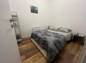 Un dormitorio con una cama y suelo de madera. en Impasse gaz 001, en Toul