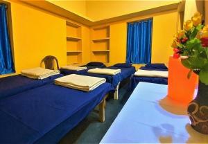 a room with four beds and a vase with flowers at The OLD house in Bolpur