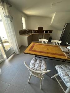 cocina con mesa, sillas y barra en Appartement T2 Calme & Parking privé, en Peypin-dʼAigues
