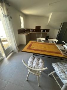 Una cocina con una mesa y sillas en una habitación. en Appartement T2 Calme & Parking privé, en Peypin-dʼAigues