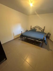 Un dormitorio con una cama en la esquina de una habitación. en Appartement T2 Calme & Parking privé, en Peypin-dʼAigues