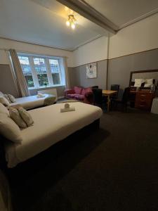 a bedroom with a bed and a living room at Piccolo Guest House in Glasgow