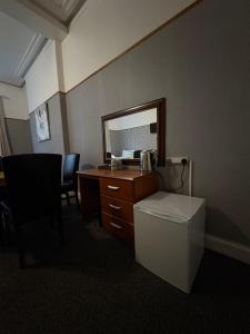a bathroom with a desk and a mirror and a toilet at Piccolo Guest House in Glasgow
