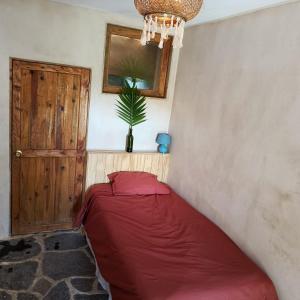 a red bed in a room with a potted plant at Casa Zapote in Sololá