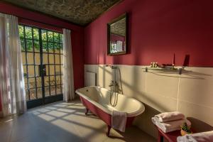 a bathroom with a tub and a red wall at Verde Oliva Casa de Huéspedes in Maipú