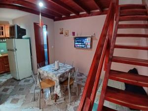 una cucina con tavolo con sedie e frigorifero di Miniduplex tipo Cabaña a San Bernardo